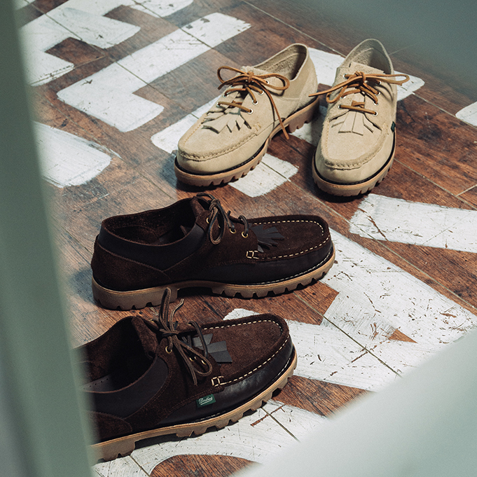 Paires de chaussures Paraboot Thiers coloris Sand et Café issues de la collaboration Universal Works, posées sur un sol texturé.