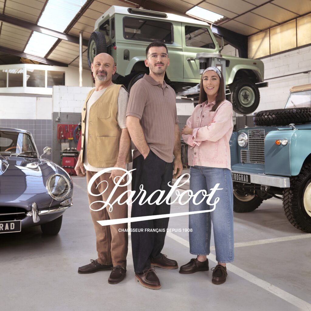 Trois artisans de l'atelier Rétrograd posant devant des véhicules anciens en portant des chaussures Paraboot.