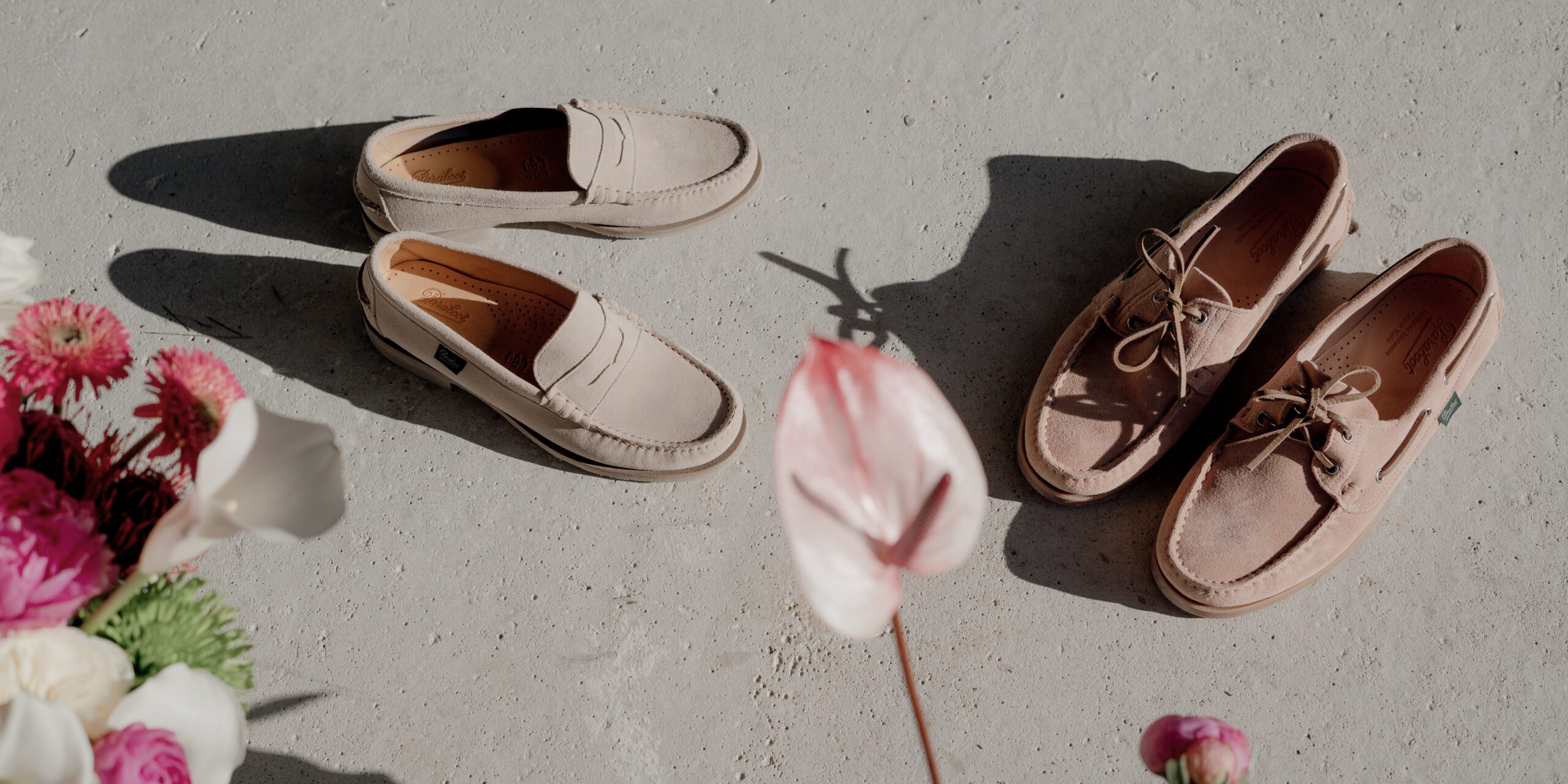 Chaussures été femme : vue de dessus d'une personne portant un mocassin Coraux mocassin Coraux en velours crème et la chaussure bateau barth en velours nude Paraboot entre des pots de fleurs colorées.