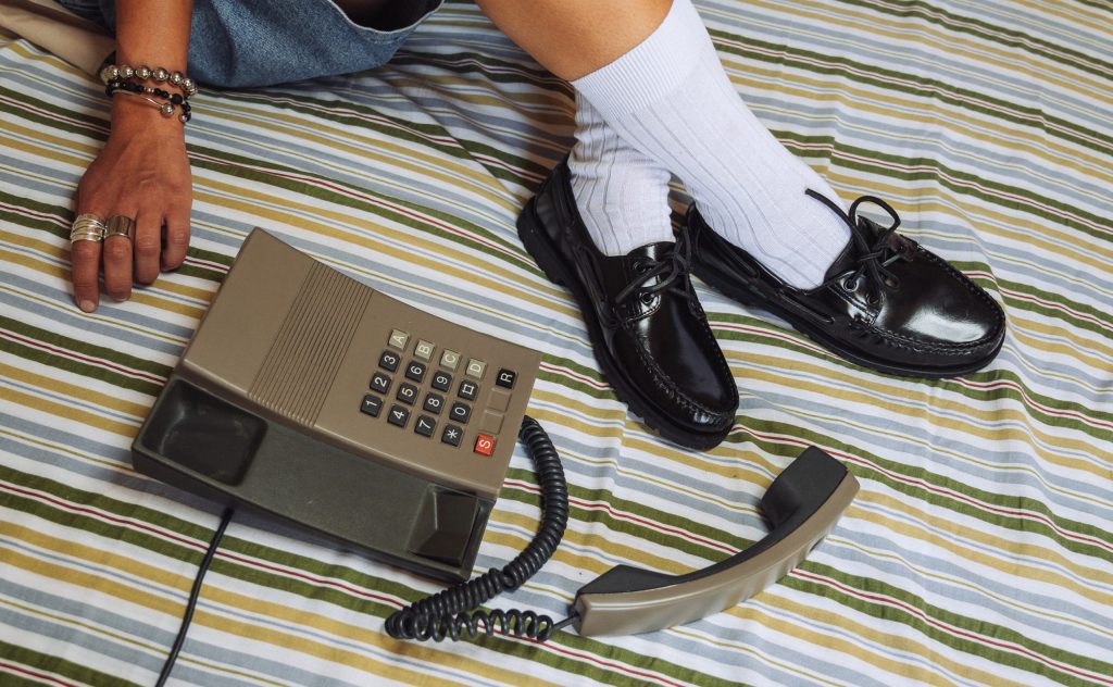 Paraboot Malo boat shoes in black polished leather with rubber soles, worn with white socks.