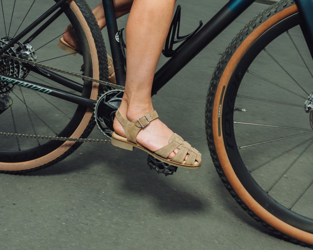 Sandale femme en cuir daim Paraboot Bilbao velours muscade sur une pédale de vélo en ville.