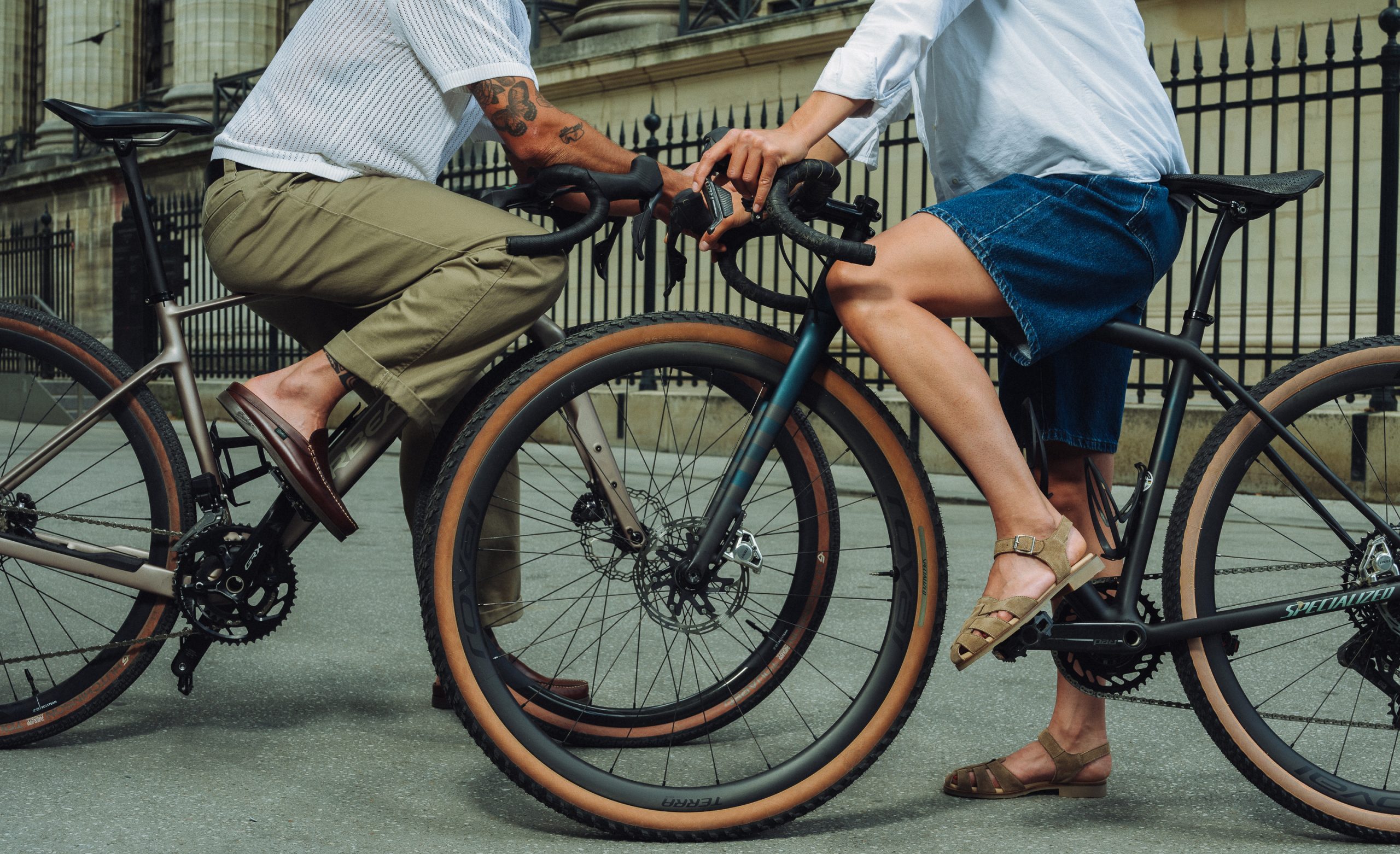 Un homme et une femme à vélo dans Paris portant des chaussures Paraboot Bahamas et sandales Bilbao.