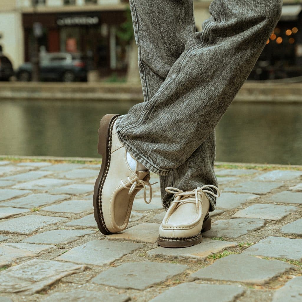 Derby Michael femme Paraboot en cuir lisse neige porté avec un pantalon en jean gris.
